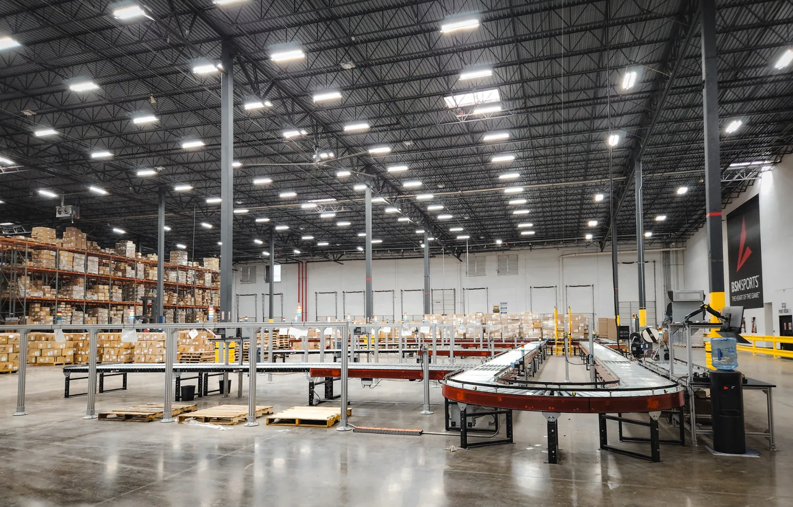 End-of-line automation system automatically packing, sealing, labeling, and palletizing goods for shipment